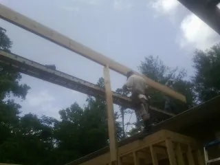 Carpenter setting a ridge beam over a new addition frame — Ice Dam Removal by Roofing Brothers in Yantic