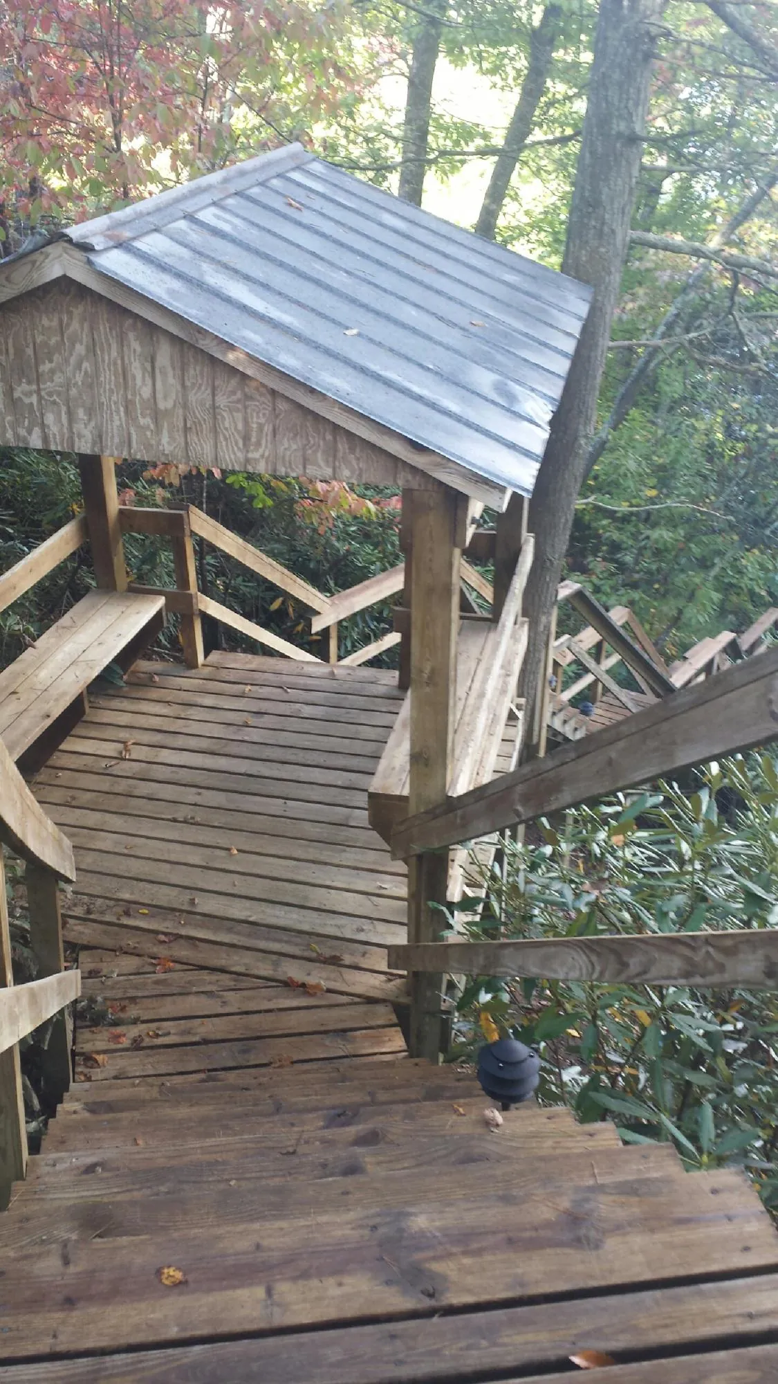 Metal roofed shelter over wooden steps on a wooded walkway — Skylight Repair & Installation work by our crew in Yantic