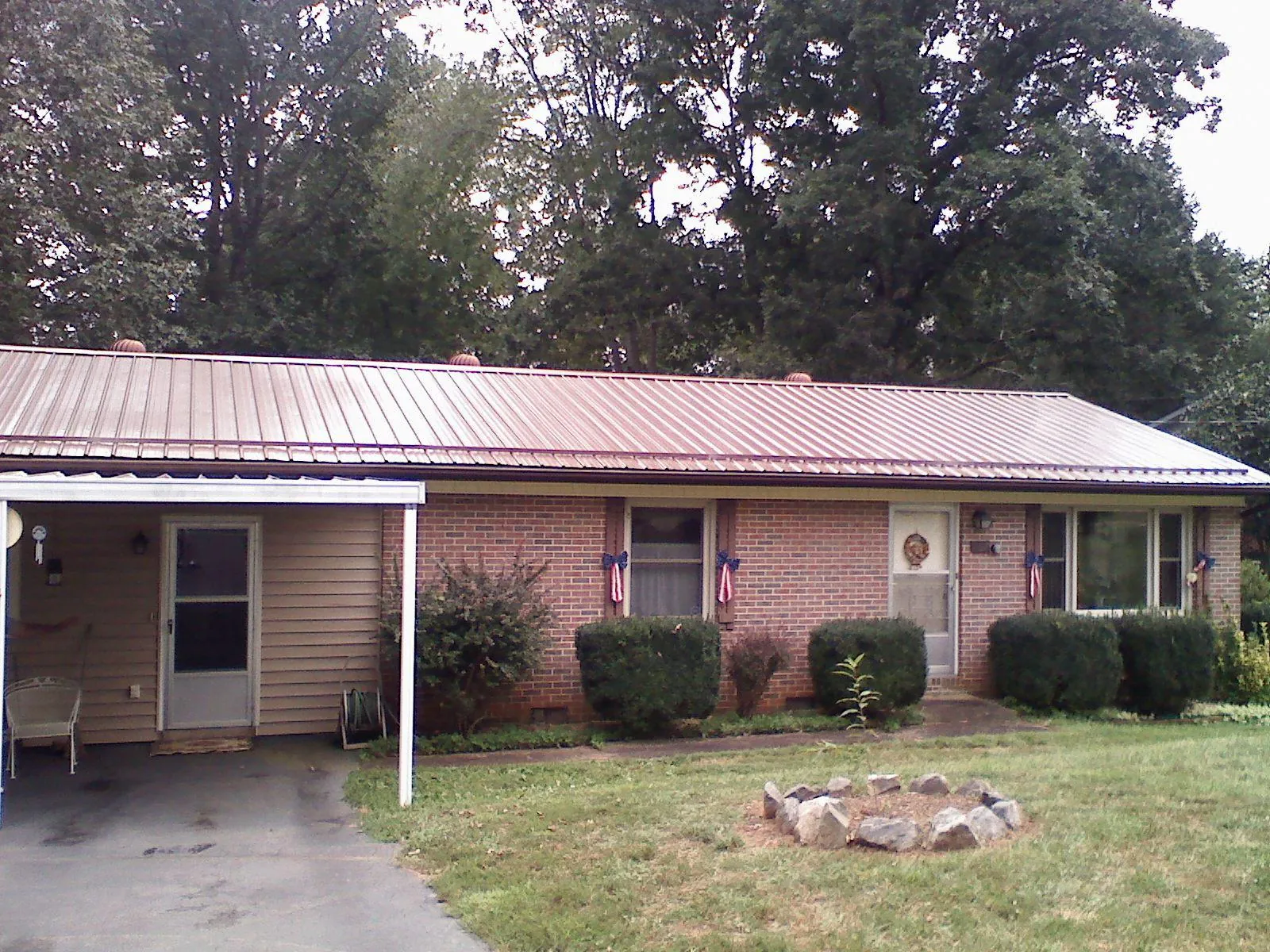 Bronze metal roof and carport on a brick ranch home — Roof Repair work by our crew in Yantic